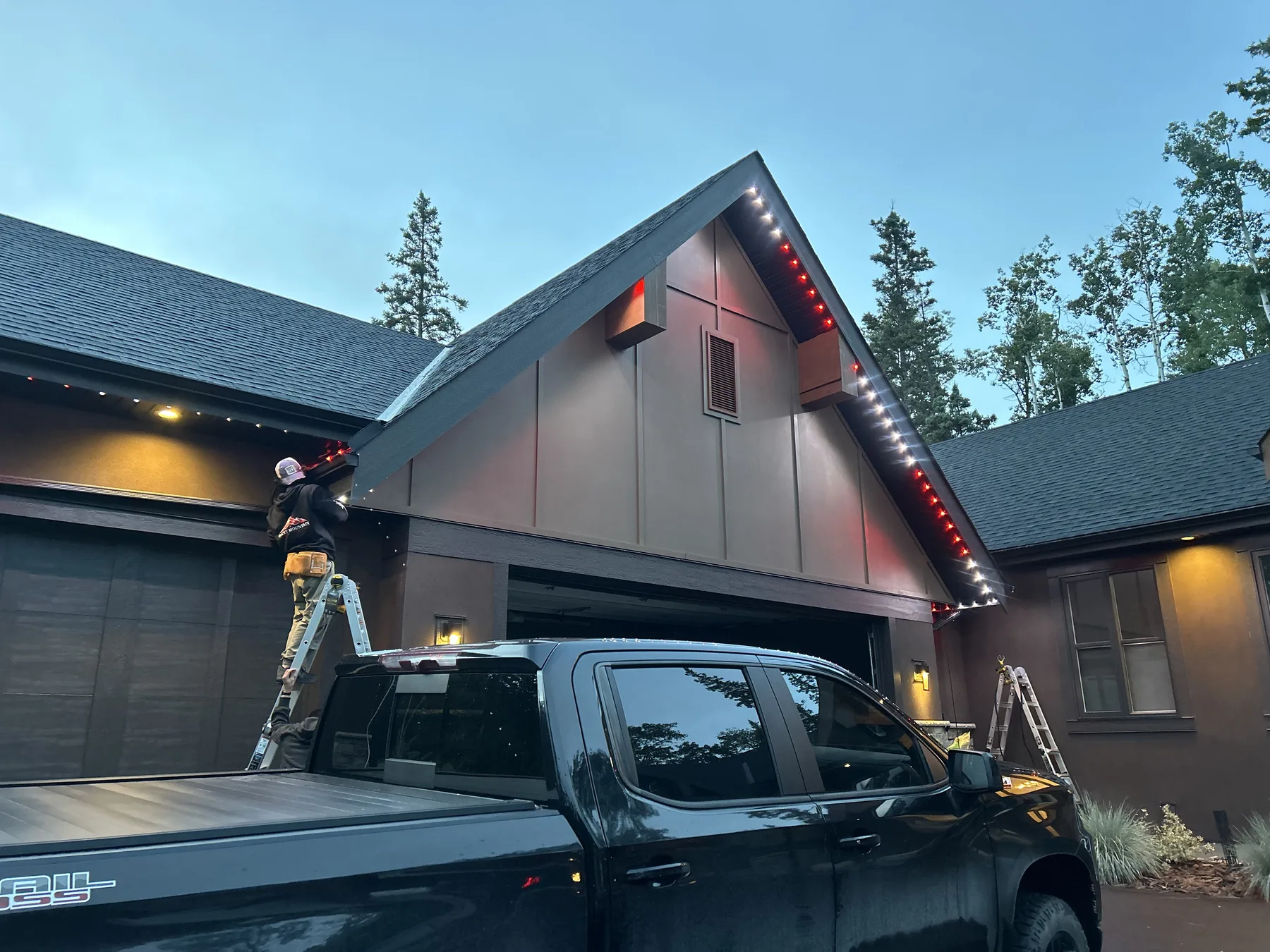 Rocky Mountain Lighting installer working on a home's roofline lighting